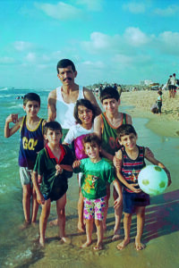 Saleem Dawood Azar junto a niños de la familia Azar en la playa de Gaza, años noventa. The Saleem Azar Collection. © PMDA